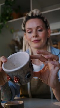 Lady potter inspects ceramic bowl interior before online listing