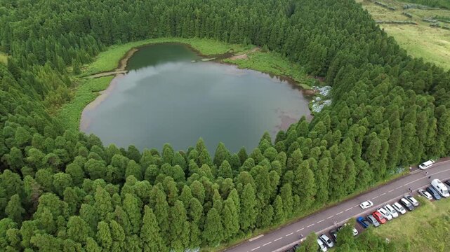 Aerial drone view of Lagoa do Canario, a volcanic crater lake surrounded by lush forest in the Sete Cidades area of Sao Miguel, Azores, Portugal
