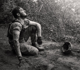 Fototapeta premium Young soldier sitting on the ground