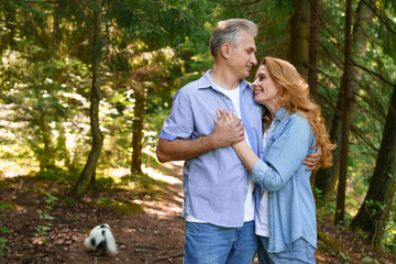 Fototapeta premium Mature Couple Embracing on a Path in a Spruce Forest