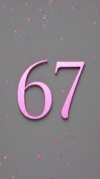 Pink Glitter Blows Away and Reveals the Number 67 on Solid Background