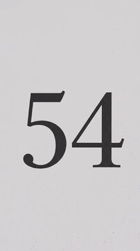 Pink Glitter Blows Away and Reveals the Number 54 on Solid Background