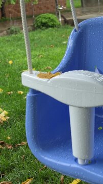 Wet Child Swing with Raindrops in Garden After Rain