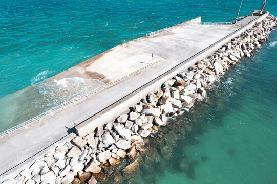 Aerial view of a concrete pier and breakwater in turquoise sea water The Concept of coastal defense