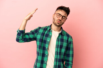Naklejka premium Young caucasian man isolated on pink background with tired and sick expression