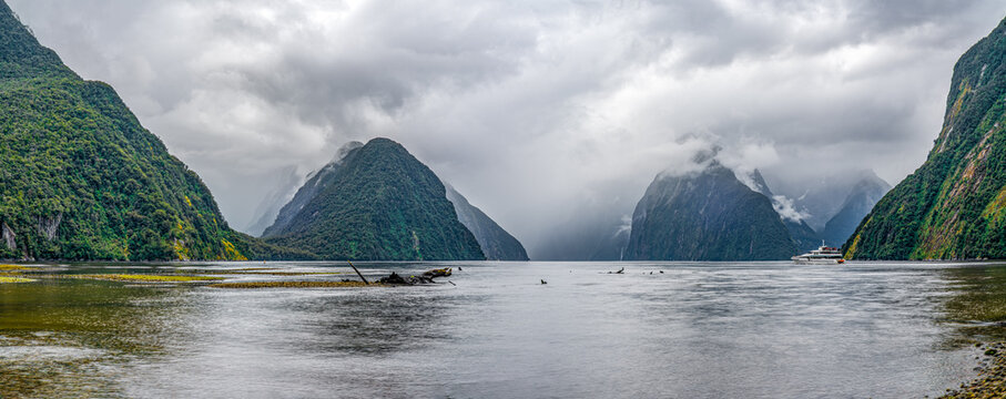 Milford Sound mit Mitre Peak im Nebel: Ausflugsboot durchquert den Fjord bei Ebbe, Fiordland-Nationalpark, Neuseeland