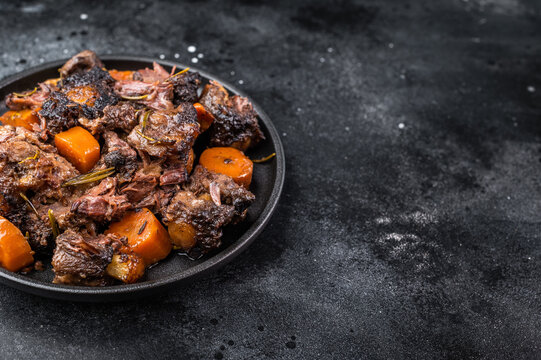 Homemade beef and lamb oxtail ragout in skillet, gelatin rich slow cooked meat with vegetables, overhead food photography