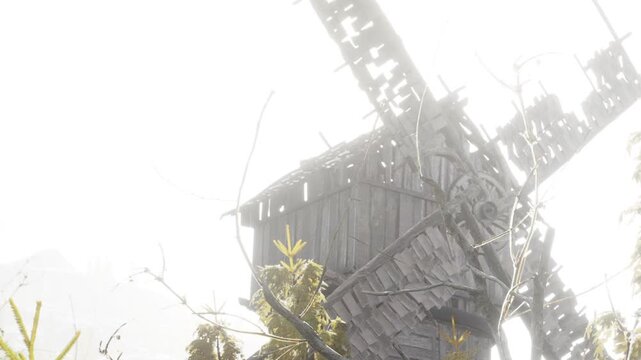 A windmill is visible in a foggy field during the early morning. The surroundings are quiet and shrouded in mist with a sense of stillness in the air.