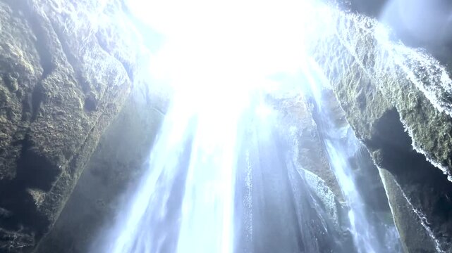 Handheld POV shot inside Gljufrabui canyon cave waterfall with heavy water spray on lens Iceland