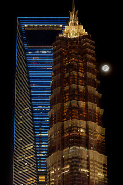 The illuminated Shanghai World Financial Center (bottle opener) and Jin Mao Tower skyscrapers by night with full moon in Pudong modern city side, Shanghai, China 30 July 2026