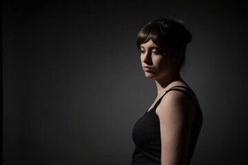 Fototapeta premium Portrait of a beautiful teenage girl posing against a dark background in beauty style
