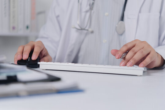 Doctor hands using computer mouse and keyboard for electronic health record
