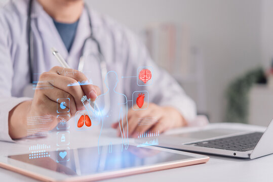 Doctor using tablet with virtual human anatomy and medical data hologram