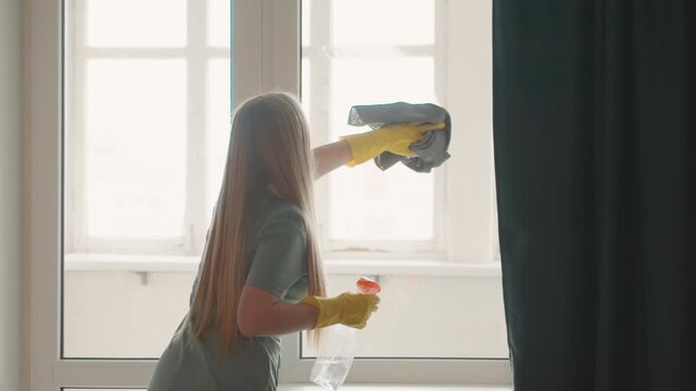 Brisk cleaning of indoor window panes with gloves. Cleaning interior house windows swiftly using spray and gloves. Quick and effective method of wiping and streak removal on household windows
