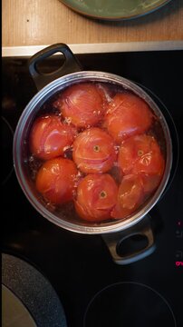 Boiling Tomatoes in a Pot for Sauce Preparation on a Modern Induction Cooktop