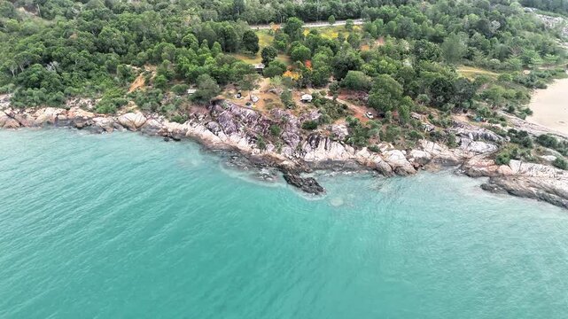 Aerial view of a tropical granite coast with turquoise ocean, rocky shoreline, lush vegetation and peaceful surroundings, ideal for travel and tourism