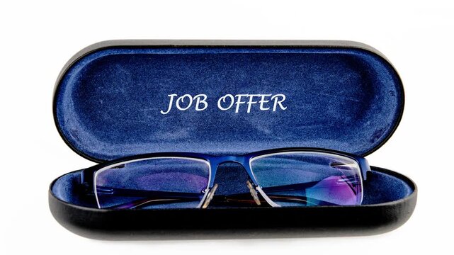 A glasses case opens to show a surprise job offer written inside. The moment captures excitement as the offer is presented in a creative way