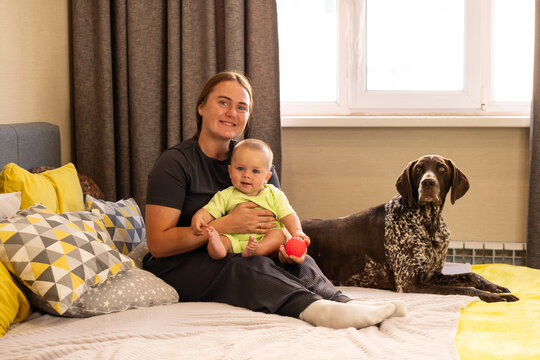 Mother and Baby Pose Beside German Shorthaired Pointer