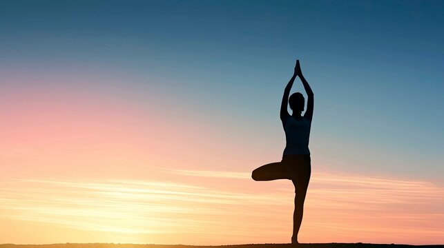 Silhouette of Woman Practicing Yoga in Tree Pose at Sunset Horizon