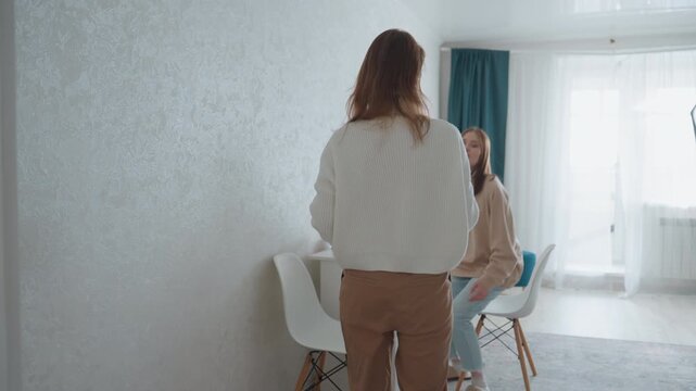 Intensive feedback session between two women in modern apartment study, coach delivers assertive correction while student practices pronunciation from workbook scenes alternate between roleplay