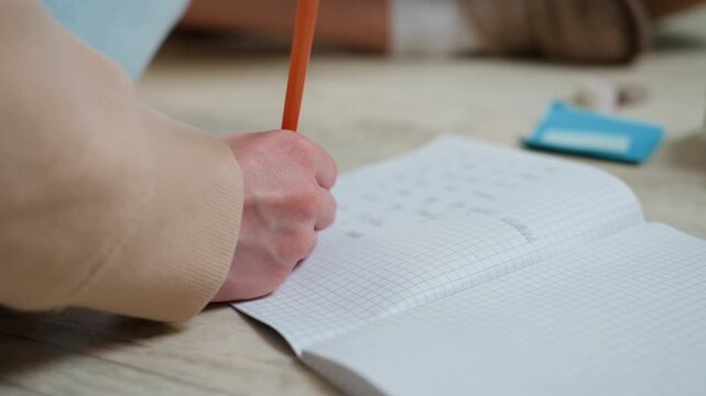 Focused notebook writing exercise. Precision in manual writing activities during exam simulations. Diligent and steady hand movements for efficient practice and learning preparation