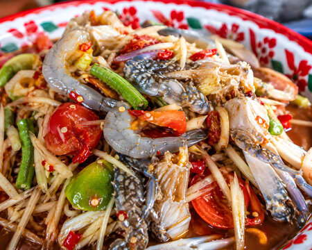 Spicy Thai papaya salad with raw seafood and fresh ingredients
