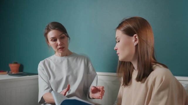 Caucasian woman coaching teen about grammar, bedroom study scene with notebook review, gentle touch reassuring, feedback on sentences, smile and eye contact, supportive correction, intimate