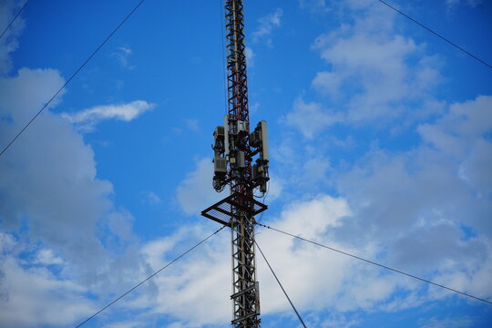 Telecommunication cell tower mast against blue cloudy sky