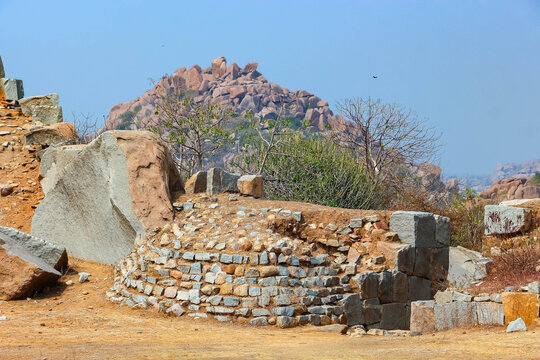 Ancient stone temple ruins and historic carved architecture in Hampi, India. Beautiful landscape with archaeological site, cultural heritage landmark and popular international tourist destination.
