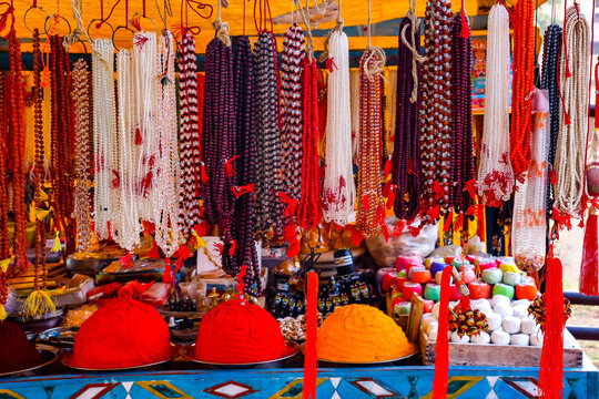 Hanging strings of traditional Indian prayer beads, japa mala and rudraksha necklaces on display at a market stall in Hampi, India. Spiritual religious accessories, meditation items and souvenirs.