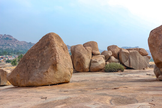 Giant natural granite boulders and rock formations on a rocky hill landscape in Hampi, India. Unique geological scenery, historic archaeological site, outdoor nature destination.