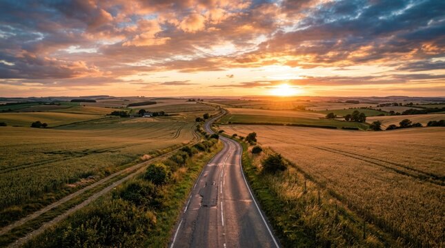 Scenic Country Road Through Golden Fields at Sunset.