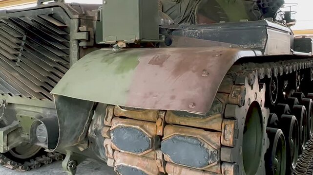 THAILAND - AUGUST 9, 2026: Heavy military battle tank operating in field training grounds, showing external armor tracks and interior tactical command cockpit equipment inside a restricted m
