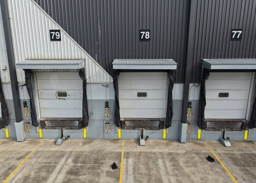 Warehouse loading dock doors with numbers 77, 78, 79