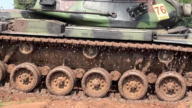 THAILAND - AUGUST 9, 2026: Heavy military battle tank operating in field training grounds, showing external armor tracks and interior tactical command cockpit equipment inside a restricted m