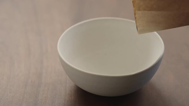 Slow motion blueberries fall in white ceramic bowl