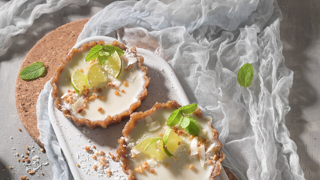 Mini lime tarts with coconut and mint on a tray