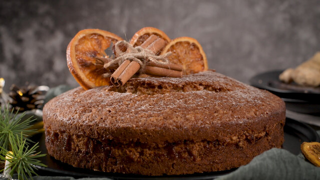 Festive spice cake decorated with dried orange slices and cinnamon sticks