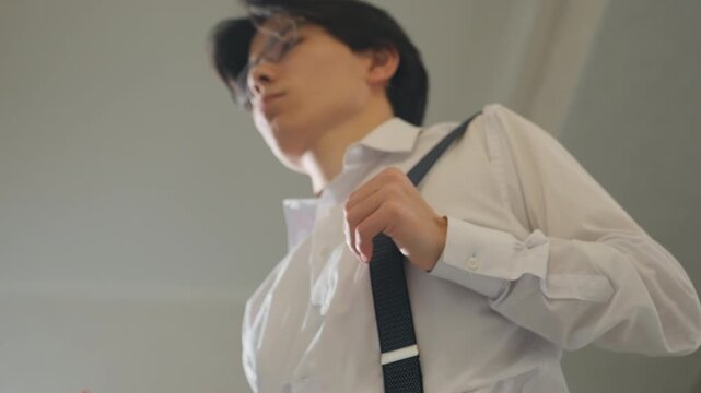 Asian man adjusting suspenders lowangle shot bold posture and confident expression, white shirt with pinstripe trousers, preparing for executive meeting, career presentation, or performance, cinematic
