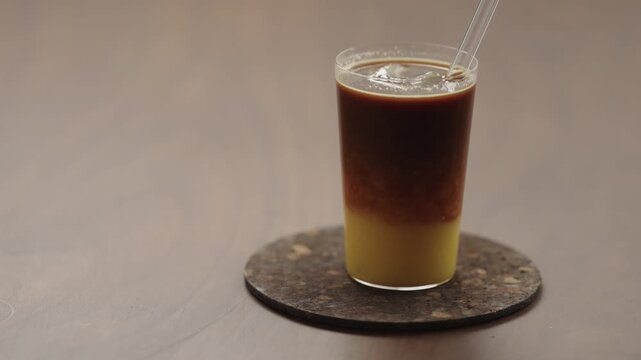 Slow motion taking a sip of bumble coffee with a glass straw