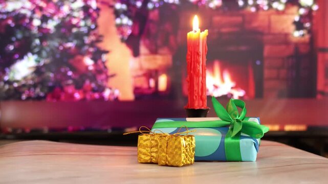 lit red candle, gifts at the base of the candle, Christmas gifts