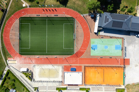 Aerial view of a modern sports stadium with a football pitch and running track.