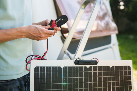 Close-up of technician hands connecting MC4 cables to a solar panel