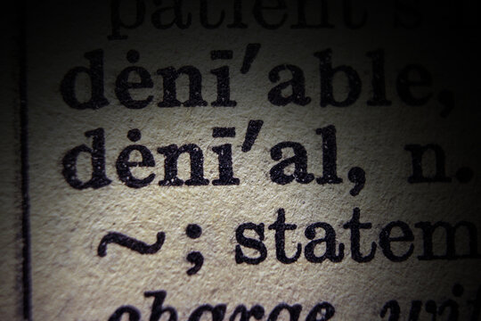 Word denial printed on dictionary page, macro close up.