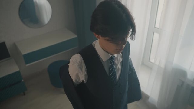 Caucasian man slipping into jacket, hotel room light and sheer curtains, smoothing lapel and straightening tie, final mirror check, steady hands, calm composed energy, cinematic soft tones,