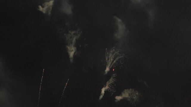 Fading firework smoke trails in dark night sky