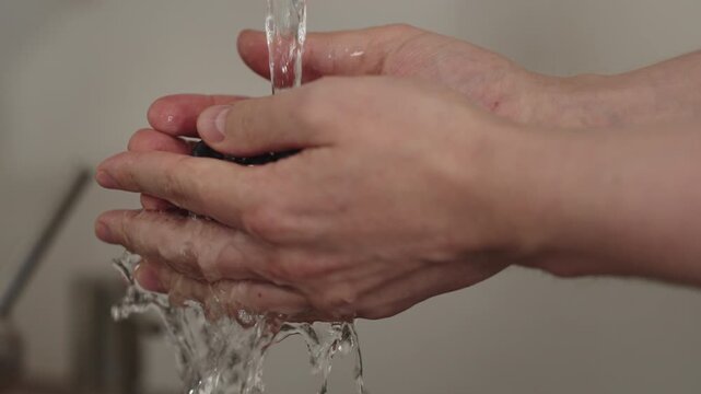 Slow motion man hand wash fresh ripe blueberry