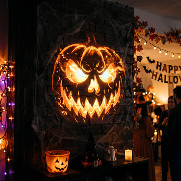 Glowing jack-o-lantern pumpkin decoration in dark Halloween room.