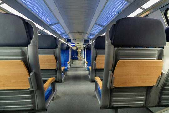 Comfortable seating inside German train carriage. Modern passenger transport interior with rows of seats, designed for convenient rail travel.