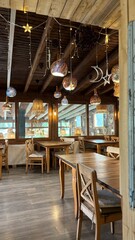 Fototapeta premium Cozy rustic restaurant interior with wooden tables and decorative hanging lamps